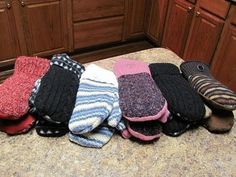 several pairs of mitts are lined up on the counter