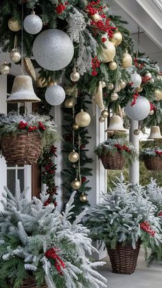 christmas decorations hanging from the side of a building with evergreens and other greenery