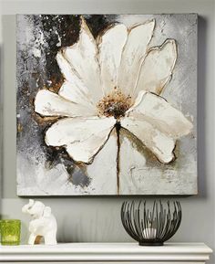 a large white flower is displayed on a wall