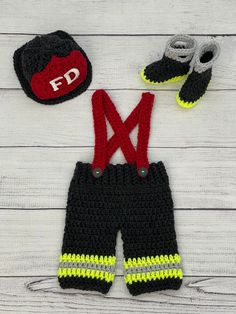 a crocheted hat, mittens and booties are laid out on a white wooden surface