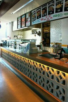 the interior of a fast food restaurant with menus hanging on the wall behind the counter