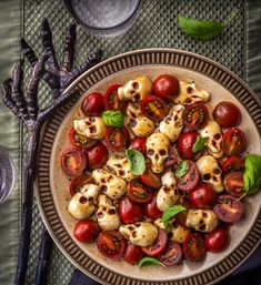 a plate full of tomatoes and skulls on top of a table next to utensils