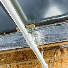 the inside of a house with exposed pipes and insulation tape on the ceiling above it