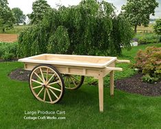 an old wooden wagon with wheels is sitting in the grass