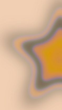 an orange and yellow star shaped object is seen in this abstract image, which appears to be blurry