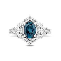 a ring with a blue stone and white diamonds on the sides, set in 18k white gold