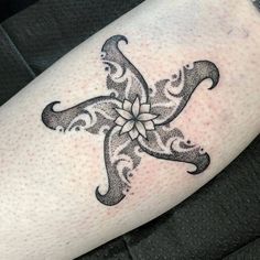 a black and white tattoo on the leg of a person's arm with an ornate cross