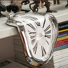 a clock that is sitting on top of a shelf next to some books and figurines