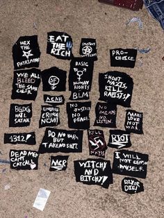 several t - shirts that have been placed on the floor with writing all over them