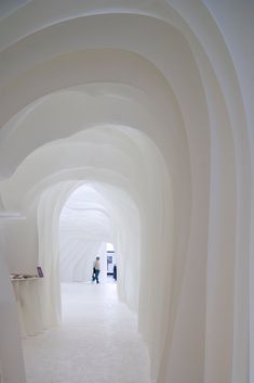 the hallway is lined with white walls and arches that are shaped to look like an arch