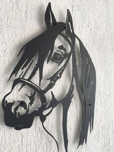 a metal horse head mounted to the side of a wall