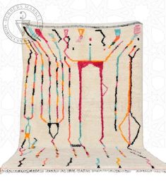 a white rug with multicolored lines and shapes on the bottom, in front of a