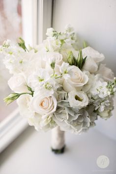 a bouquet of white flowers sitting on top of a window sill