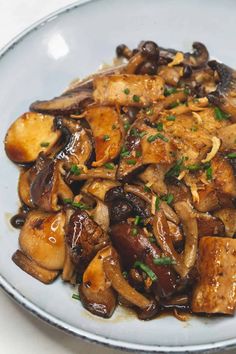 a white plate topped with mushrooms and meat