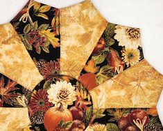 an umbrella with autumn leaves and flowers on it is shown in the middle of this image