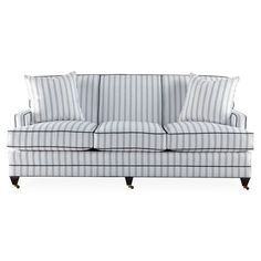 a blue and white striped couch with two pillows on top of the armrests