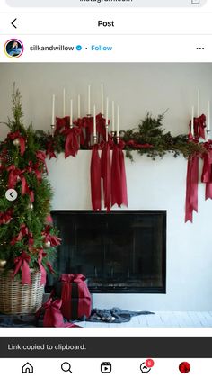 a fireplace decorated for christmas with red bows and candles