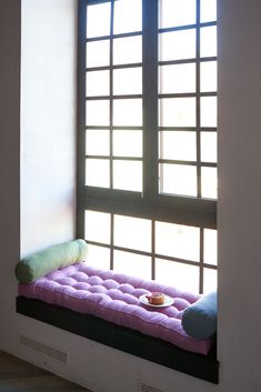 a window sill with a pink cushion on it