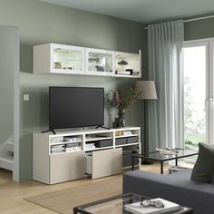 a living room filled with furniture and a flat screen tv on top of a entertainment center