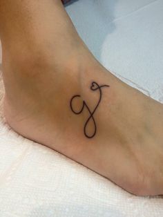 a person with a tattoo on their foot that has the letter s and an arrow