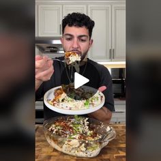 a man eating food from a plate on top of a wooden table