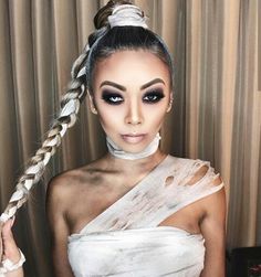 a woman in white dress with braids on her head and makeup applied to look like an egyptian queen