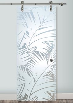 an image of a glass door with palm leaves etched on it in front of a white wall