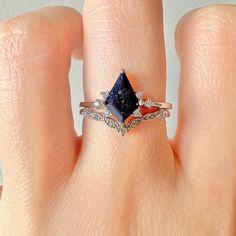 a woman's hand with a ring on it and a blue diamond in the middle