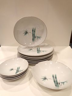 four white plates with green bamboo designs on them