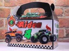 a box with monster trucks on it sitting next to a brick wall