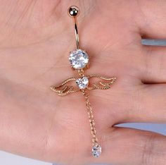 a person's hand with a gold colored dragon belly ring