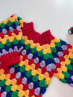 a crocheted piece of cloth sitting on top of a white table next to a pair of scissors