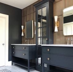 a bathroom with two sinks and mirrors on the wall, along with an area rug