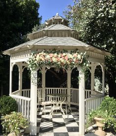 a white gazebo with flowers on the top