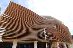 a large wooden building with people walking around it