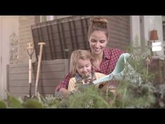 a mother and daughter are looking at something in the grass outside their house with gardening tools