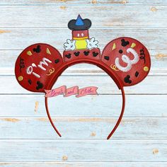 a red mickey mouse ears headband with the number 30 on it's side