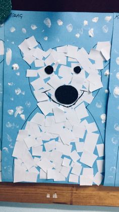 a polar bear made out of paper on a blue background with white snow flakes