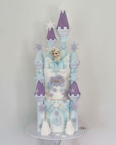 a frozen princess castle cake is shown on a table