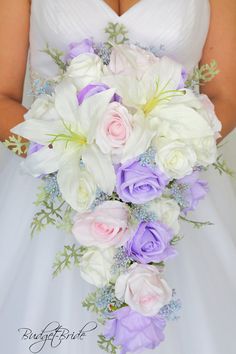 a bride holding a bouquet of white and purple flowers