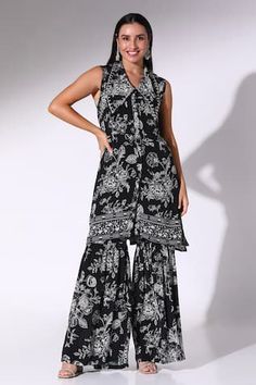 Black floral print kurta with a statement silver stone embellished lapel collar. Paired with a sharara style pant.
Components: 2
Pattern: Printed
Type Of Work: Floral
Neckline: V Neck
Sleeve Type: Sleeveless
Fabric: Crepe
Color: Black
Occasion: Work - Aza Fashions Bohemian Sleeveless Sets With Floral Print, Bohemian Floral Print Sleeveless Sets, Bohemian Sleeveless Floral Print Set, Sleeveless Floral Print Festive Sets, Bohemian Sleeveless Sharara For Navratri, Festive Sleeveless Palazzo Set With Printed Motifs, Designer Sleeveless Sets With Floral Print, Bohemian Sleeveless Sharara For Summer, Sleeveless Sets With Floral Print For Designer Look