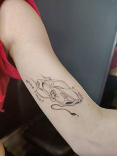 a woman's arm with a tattoo on it that has a drawing of a car