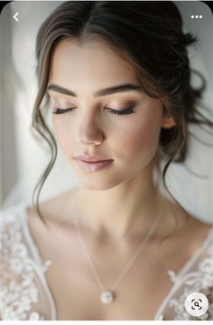 a woman with her eyes closed wearing a white dress and pearls on the necklace is looking down