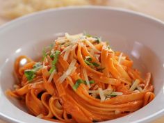 a white bowl filled with pasta and parmesan cheese