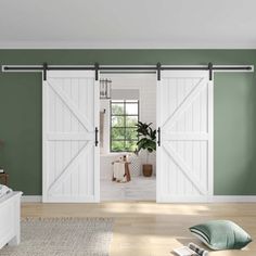 a bedroom with green walls and white sliding barn doors in the middle of the room