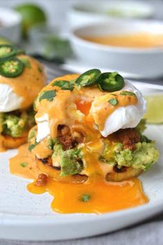 two appetizers are sitting on a plate with sauce and green garnish