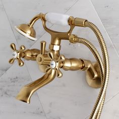 a gold faucet with two spray heads and three hoses attached to it