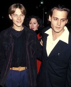 two young men standing next to each other in front of a crowd at an event