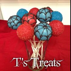 a vase filled with red, white and blue cake pops on top of a table