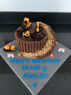 a birthday cake with construction trucks on it and the words happy birthday ollie & finnley 4